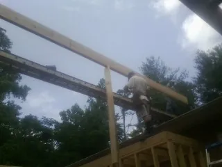 Carpenter setting a ridge beam over a new addition frame — Ice Dam Removal by Roofing Brothers in Moundridge