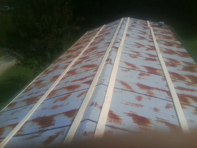 Rusted metal roof panels with new wood purlins before replacement — Storm Damage Roof Repair in Moundridge by Roofing Brothers