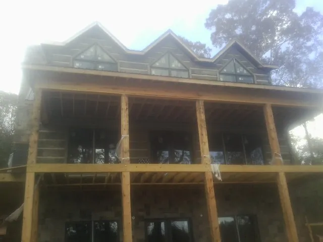 Dormers and porch framing on a large log home under construction — Roof Coating work by our crew in Moundridge