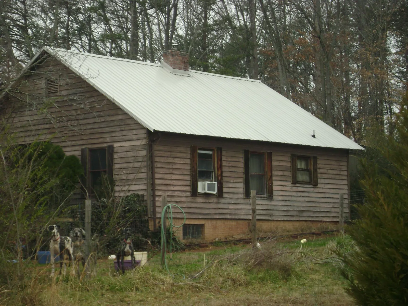 White metal roof on an old wood sided farmhouse, from a Asphalt Shingle Roof Repair job in Moundridge